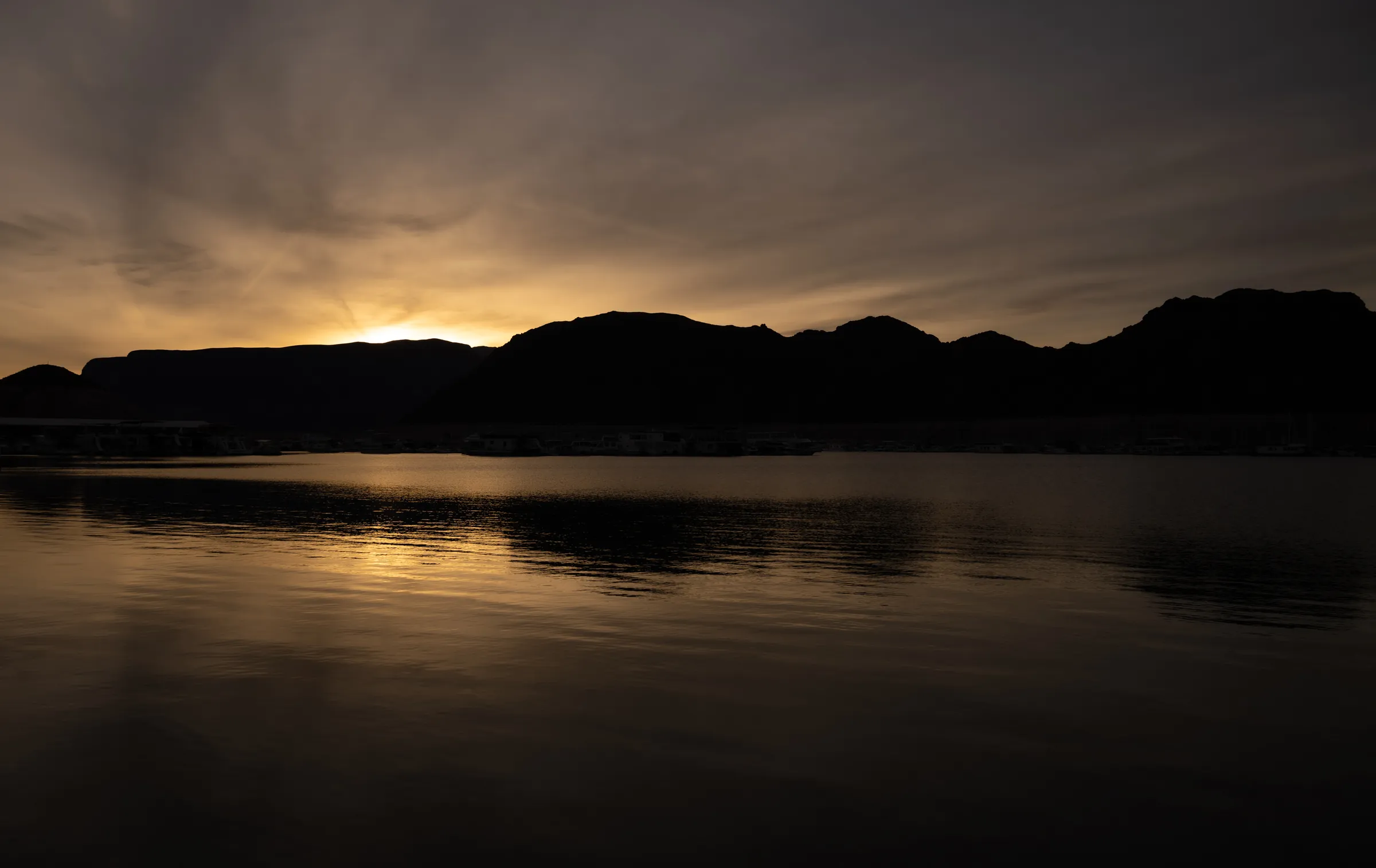 Desert mountain ridge silhouetted at sunset over calm water in Southern Nevada