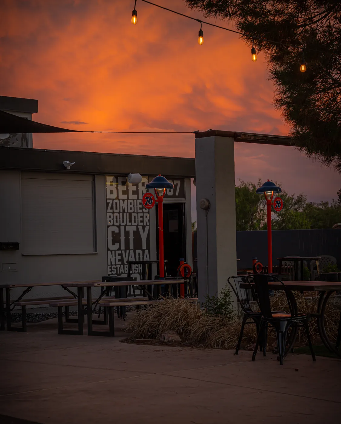 Boulder City brewery patio with string lights under a vivid orange sunset sky